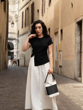 A woman wears a knit top and a pair of pants